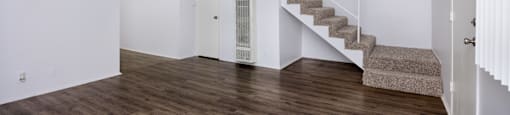 A room with wooden floors and a staircase.