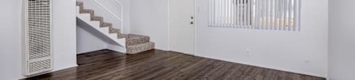 A room with wooden floors and a staircase.