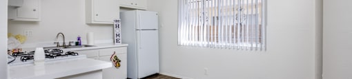 A kitchen with white cabinets and a white counter top.