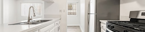 A modern kitchen with white cabinets and stainless steel appliances.