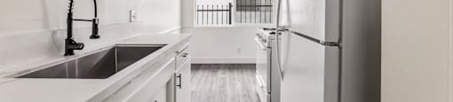 A kitchen with white cabinets and a stainless steel refrigerator.