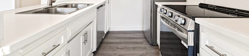 A kitchen with white cabinets and a black stove top oven.