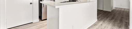 A kitchen with white cabinets and a white island.