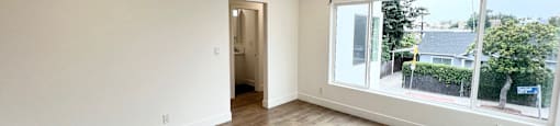 a living room with wood floors and a large window