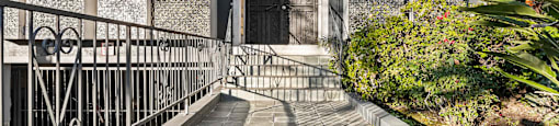 A building with a black door and a metal railing.