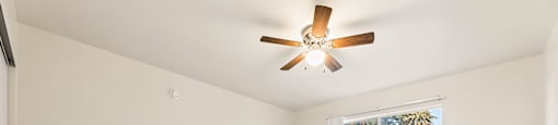 Empty room with a ceiling fan and a window.