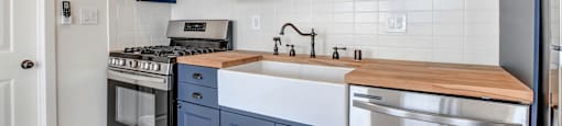 a kitchen with blue cabinets and stainless steel appliances and a sink