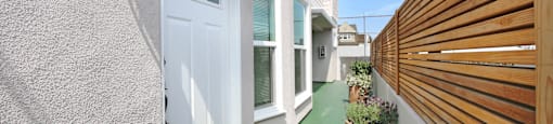 the entrance to a house with a white door and a wooden fence