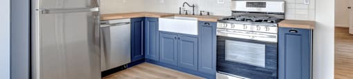 a kitchen with blue cabinets and stainless steel appliances
