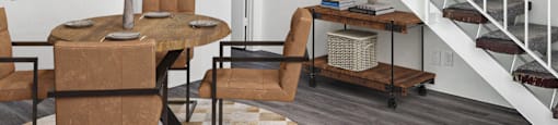 a living room with a staircase and a table and chairs