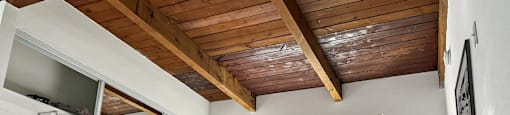 a lofted bedroom with a bed and a wooden ceiling