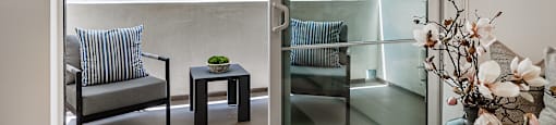 A living room with a couch, chair, and a table with a bowl on it.