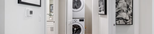 A white laundry room with a washer and dryer stacked on top of each other.