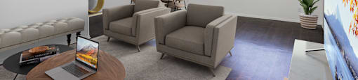a living room with couches and chairs and a table with a laptop