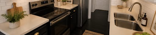 A kitchen with black appliances and white cabinets.