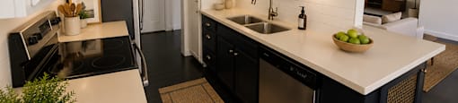 A kitchen with black appliances and white cabinets.