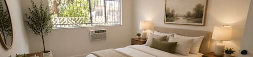 A bedroom with a large bed and a window.