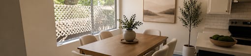 A dining room with a table and chairs.