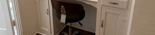 a desk with a mirror and a chair in a room