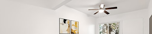 A bedroom with a large bed and a ceiling fan.