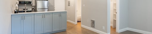 a kitchen and living room with blue cabinets and a wood floor