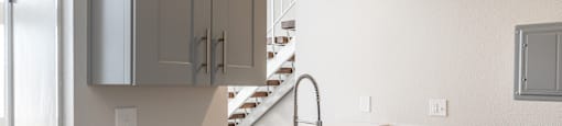 an empty kitchen with a sink and a staircase