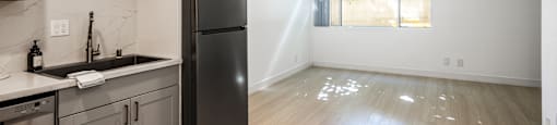 an empty kitchen with stainless steel appliances and a window