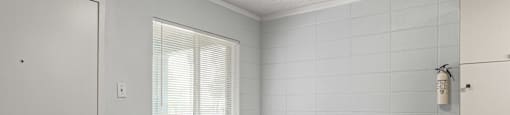 a bedroom with white walls and hardwood floors