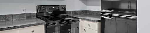 a kitchen with white cabinets and black and white appliances