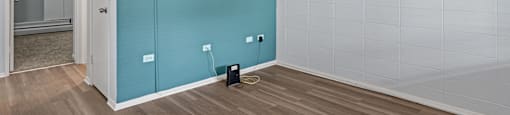 a room with a hardwood floor and a blue wall
