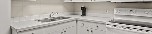 a kitchen with white cabinets and white appliances