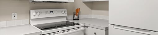 a kitchen with white cabinets and white appliances