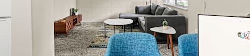 a living room with white walls and blue furniture