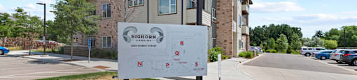 an apartment building with a sign in front of it