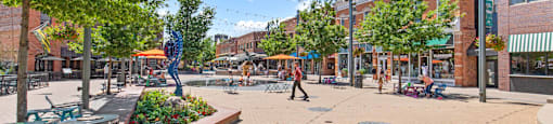 A sunny day in a pedestrian plaza with a person walking.