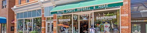 A storefront with a green awning that sells retro sports apparel.