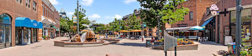 a park with a fountain in the middle of a city street