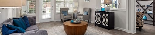 A living room with a grey couch and a wooden coffee table.