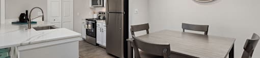 A kitchen with a table and chairs in the middle of the room.