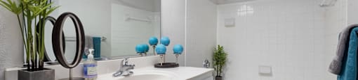 A white bathroom with a white sink and a white bathtub.