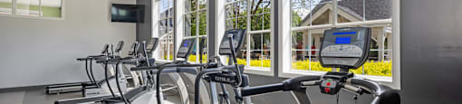 A gym with treadmills and a television.