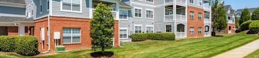 A large apartment complex with a well-maintained lawn in front.