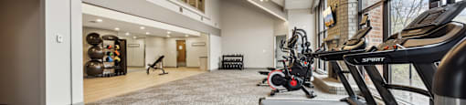 a gym with treadmills and other exercise equipment in the lobby of a building