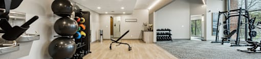 a workout room with weights and mirrors and a large window