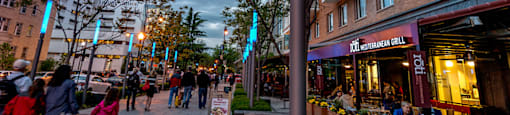 A street scene with people walking and a restaurant in the background.  at The 925 Apartments, Washington, DC