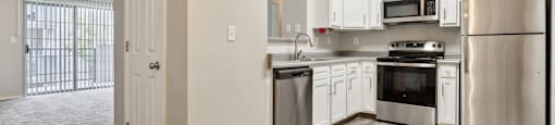 the spacious kitchen with stainless steel appliances and white cabinets
