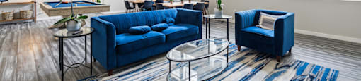 an open living room with blue couches and a pool table