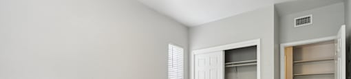 an empty bedroom with a closet and a door to the bathroom