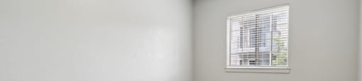 an empty room with carpet and a window