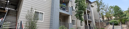 an exterior view of an apartment building with stairs and landscaping